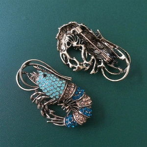 Detailed front and back views of vintage rhinestone lobster brooches with pins