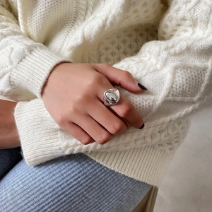 Macro shot of vintage oval silver ring with textured edge on a knit background