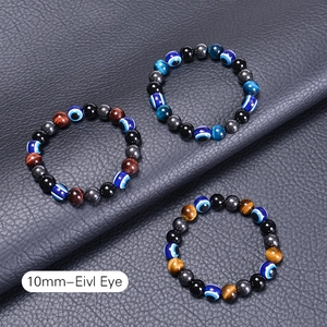 Three-piece 10mm tiger eye and evil eye beaded bracelets on black leather surface