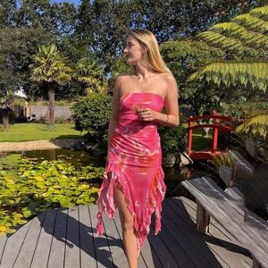 Robe bustier rose avec volants et imprimé artistique dans un décor de jardin luxuriant