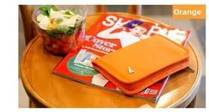 Detail view of the yellow passport organizer with zipper on a fashion magazine
