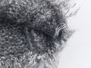 Vista macro del tessuto in maglia grigio mohair con trama soffice e misto lana pregiato