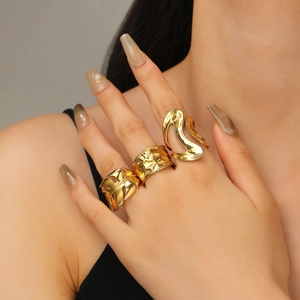 Three-piece gold-plated stainless steel rings with textured, leaf, and organic designs
