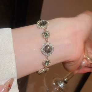 Detailansicht des silbernen Armbands mit grünen Edelsteinen und funkelnden Strasssteinen