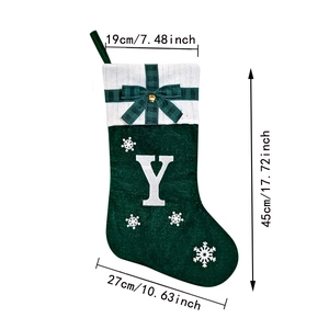 Detail of green felt Christmas stocking with embroidered Y and white snowflake patterns