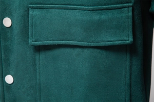 Détail de veste en daim vert foncé avec poches cargo à rabat et boutons argentés mats