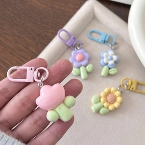 Cute chubby flower keychain in pastel colors with matching carabiner clip on a tray
