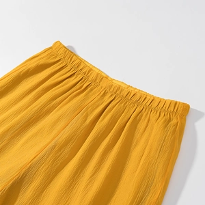 Close-up of yellow elastic waistband with pleated texture on ruffle trim shorts
