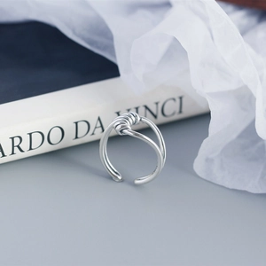 Macro shot of silver S925 multi-strand wire wrapped ring on a book backdrop