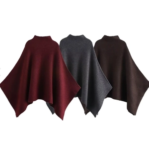 Detail view of knitted capes in wine red, dark gray, and coffee brown colors