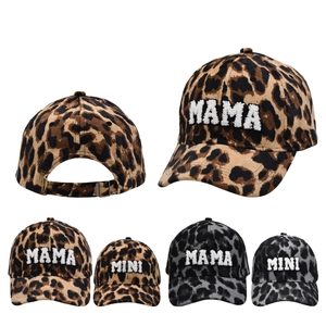 Close-up of leopard corduroy caps with MAMA and MINI fuzzy letter embroidery