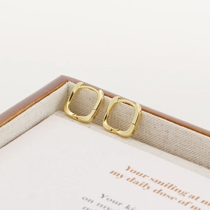 Close-up of minimalist gold square geometric hoop earrings placed in a jewelry box