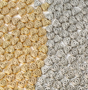 Flat lay of heart-shaped CCB beads in gold and silver with relief texture for DIY jewelry