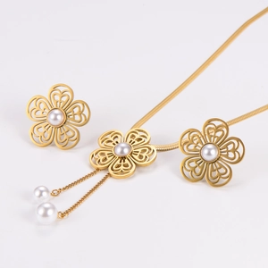 Detail of gold hollow flower jewelry set with pearls and tassel chain elements