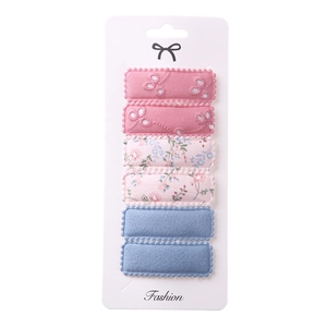 Detail view of 6-piece embroidered floral fabric hair clips on a display card