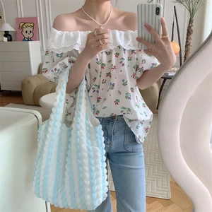 Detail of blue and white striped handbag with bubble texture and floral chiffon top