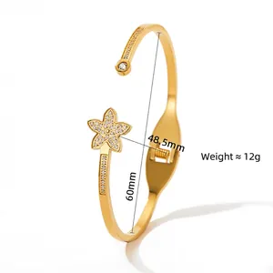 Adjustable gold flower bangle with crystal inlay shown in a professional 45-degree side view