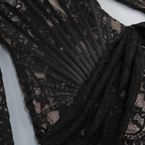 Détail de la dentelle florale et des baleines de corset en satin sur robe noire