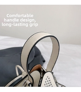 Detail of the thickened white faux leather handle with black edge paint and silver rivets