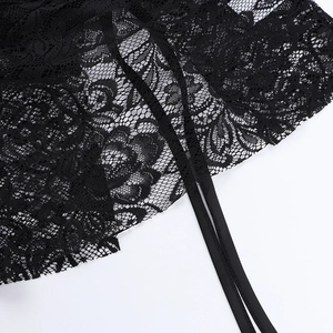 Détails de la dentelle florale noire et des fines bretelles sur un crop top d'été