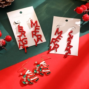 Detailed view of festive Christmas earrings featuring glitter letters and rhinestone Santa studs