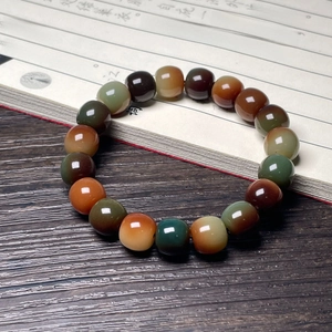 Detailed view of polished multi-colored agate beads on a vintage wooden desk with calligraphy