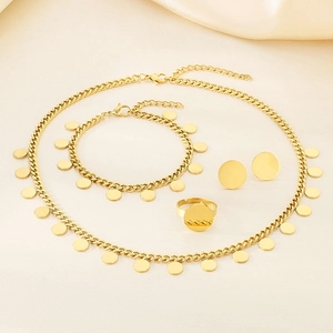 Flat lay of gold plated four-piece jewelry set including cuban chain and round discs