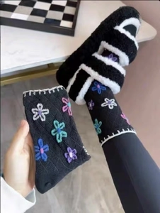 Detailed view of black knitted crew socks with colorful 3D floral embroidery design