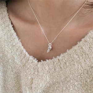 Minimalist 925 sterling silver knotted pendant necklace worn on a beige sweater