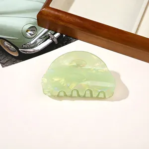 Detail of light green marble patterned hair claw clip with pearlescent resin finish