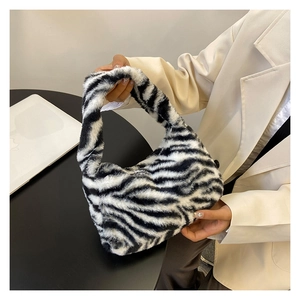 Detailed shot of plush faux fur handbag featuring a stylish black and white zebra pattern