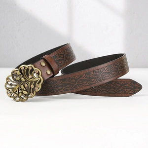 Detail of brown leather belt with vine embossing and bronze bee buckle with rhinestones