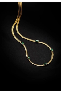 Dettaglio della collana a catena piatta dorata con cinque pietre rettangolari verdi