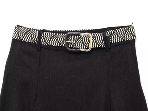 Detailed view of black linen-blend skirt waist with black and white braided belt