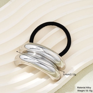 Close-up of a silver alloy hair ring on a ceramic tray with size and weight specs