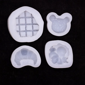 Set of 4 silicone molds for waffle, croissant, and bear shapes on a black background
