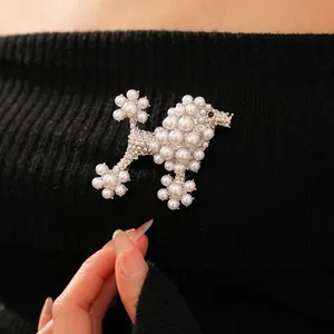 Vintage style poodle pearl brooch with rhinestones worn on a black knit sweater