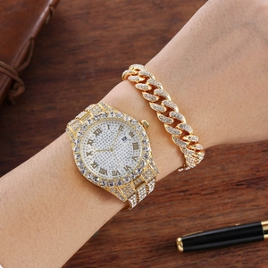 Macro detail of the golden iced-out watch and Cuban link bracelet set on a wrist