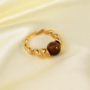 Detail of twisted rope band ring with 18K gold plating and brown spherical gemstone