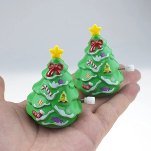 Detail of two green clockwork Christmas tree walking toys with stars and festive patterns