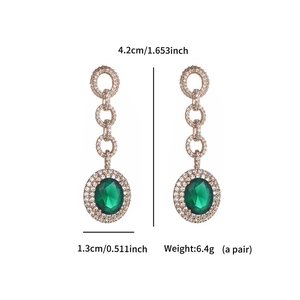 Detail of emerald drop earrings showing dimensions 4.2cm by 1.3cm on a white background