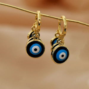 Close-up of golden drop earrings with three colorful evil eye pendants and turquoise details