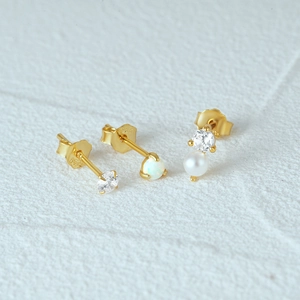 Macro shot of gold S925 sterling silver studs with opal, pearl, and zircon stones