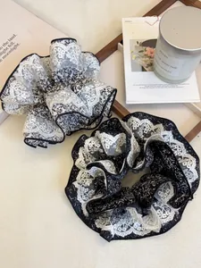 Détail de chouchous en mousseline florale avec bordure en dentelle et texture plissée