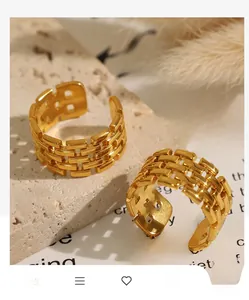 Macro shot of two gold chunky chain rings with brick texture on natural stone