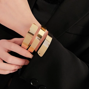 Polished gold multi-layer spiral arm cuff shown on model wrist for a bold fashion look