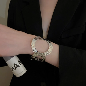 Detailed close-up of textured wide cuff bracelet with geometric hollow circle design
