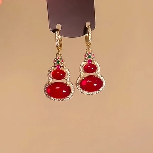 Detailed close-up of 14k gold-plated gourd earrings with red gemstones and colorful zircon
