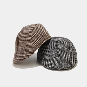 Detail of plaid ivy caps in brown and grey with premium wool blend woven texture