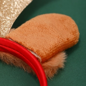 Détail des oreilles en peluche marron et serre-tête rouge avec paillettes dorées